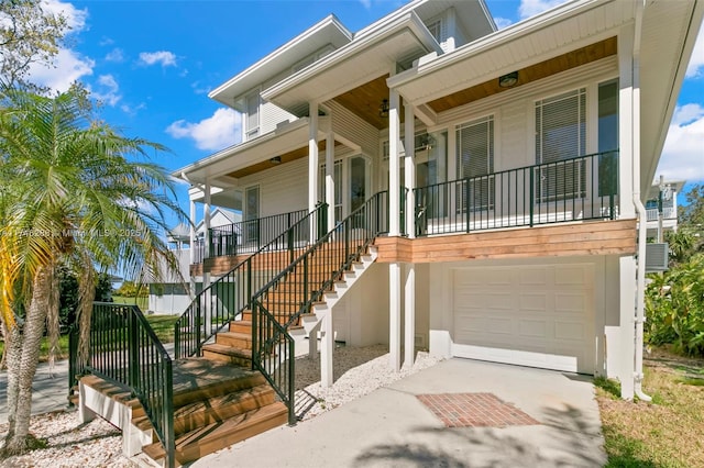 view of front facade featuring a porch, driveway, stairway, and a garage