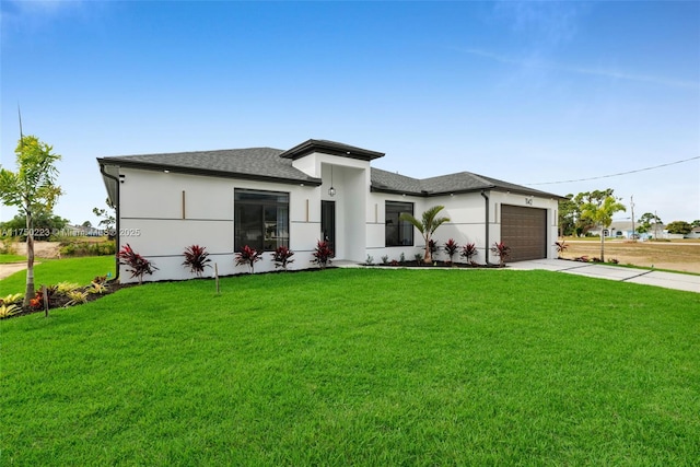 prairie-style house with a garage, a shingled roof, driveway, stucco siding, and a front yard