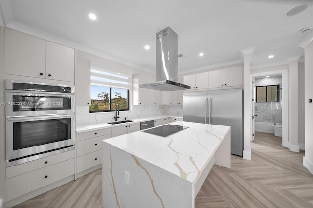 kitchen featuring island range hood, a kitchen island, a sink, stainless steel appliances, and backsplash