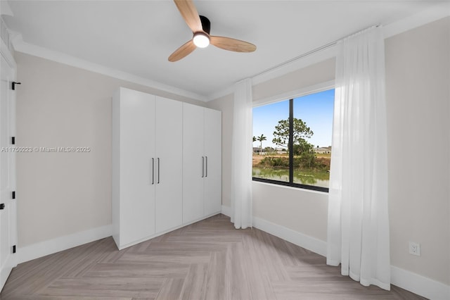 unfurnished bedroom featuring a ceiling fan, a closet, crown molding, and baseboards