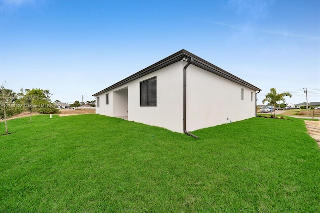 view of home's exterior with a yard and stucco siding