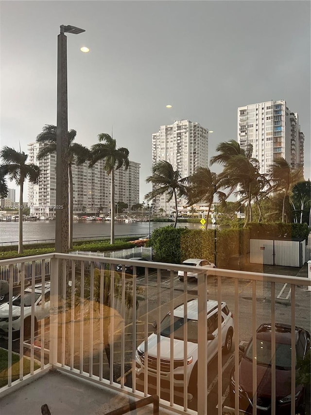 balcony featuring a water view and a city view