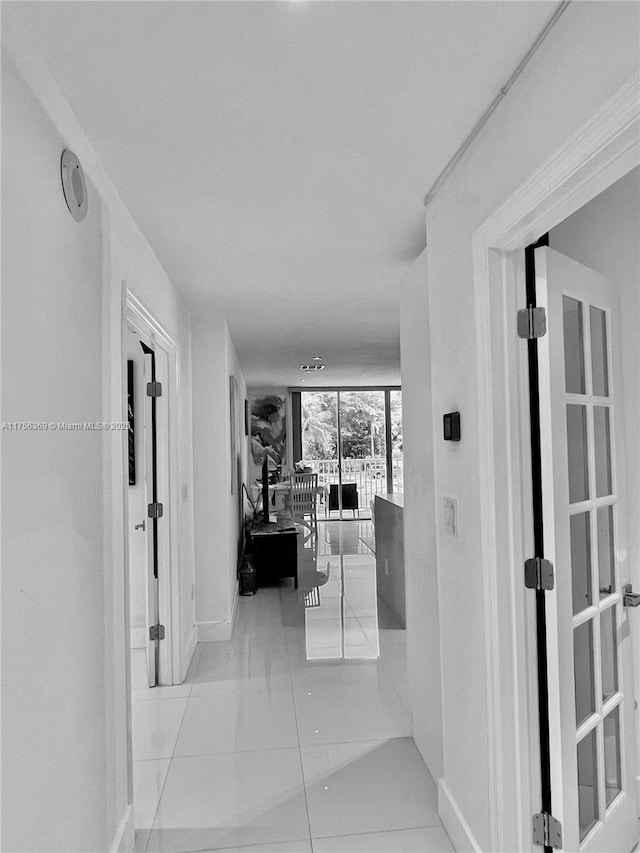 corridor featuring baseboards and tile patterned floors