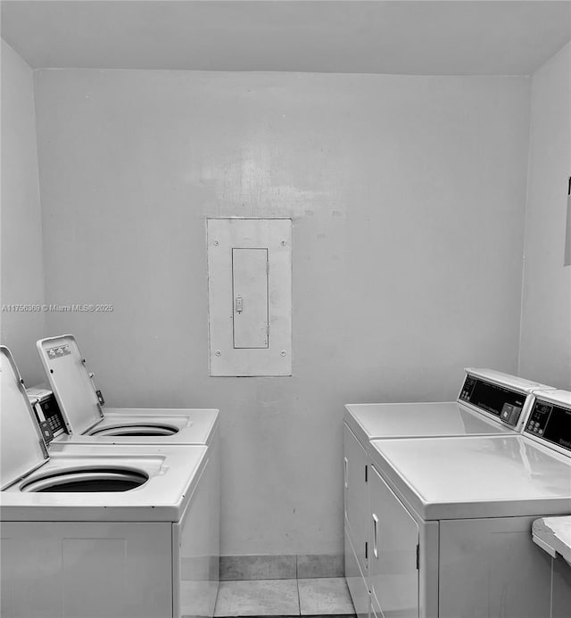 shared laundry area with light tile patterned floors, washer and clothes dryer, and electric panel