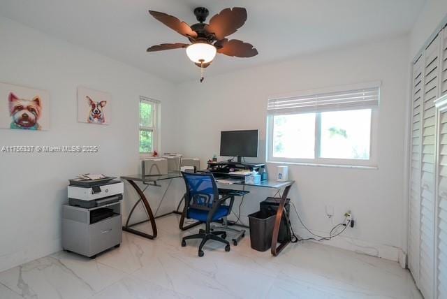 office space featuring marble finish floor and ceiling fan
