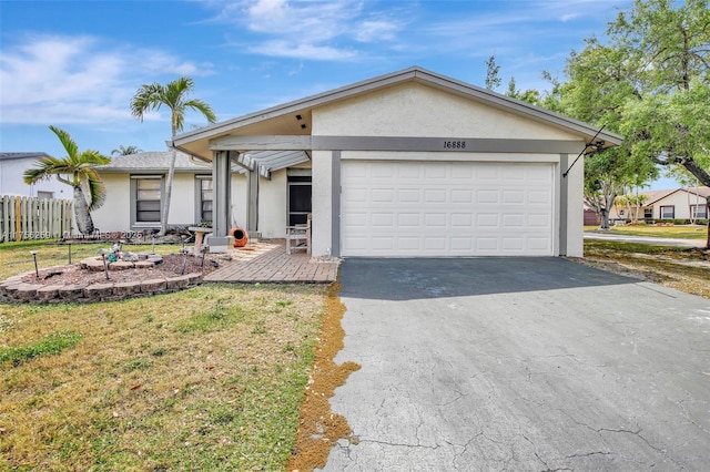 ranch-style house with an attached garage, fence, driveway, stucco siding, and a front lawn