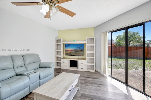 living area featuring a ceiling fan, a textured ceiling, and wood finished floors