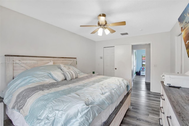 bedroom with wood finished floors, visible vents, a ceiling fan, baseboards, and a closet