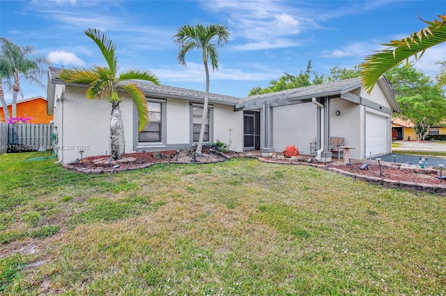 view of front of house featuring a garage, a front lawn, fence, and stucco siding