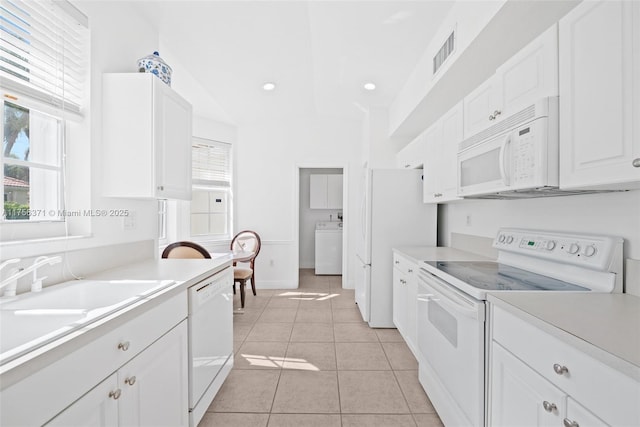 kitchen with white cabinetry, washer / clothes dryer, visible vents, light countertops, and white appliances