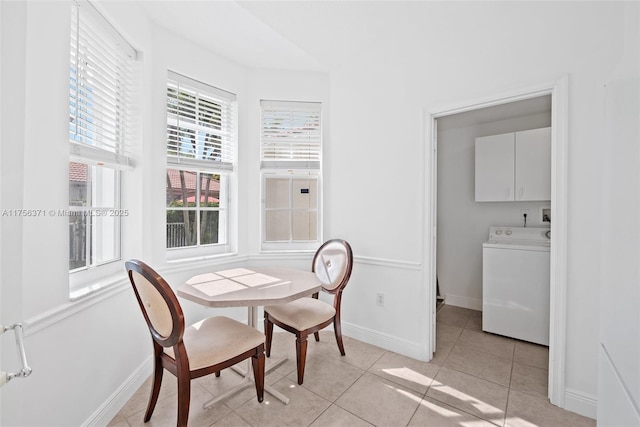 dining space featuring baseboards, light tile patterned floors, and washer / dryer