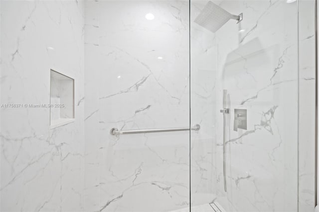bathroom featuring a marble finish shower
