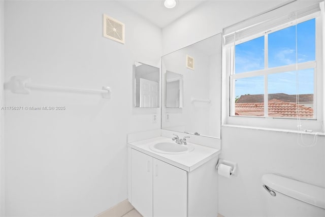 bathroom featuring toilet, visible vents, and vanity