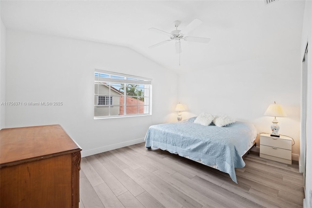 bedroom with baseboards, a ceiling fan, light wood finished floors, and vaulted ceiling