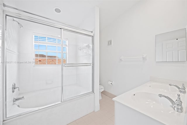 bathroom with bath / shower combo with glass door, double vanity, visible vents, toilet, and tile patterned floors
