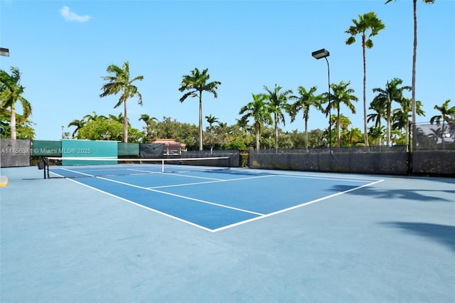 view of tennis court with community basketball court and fence