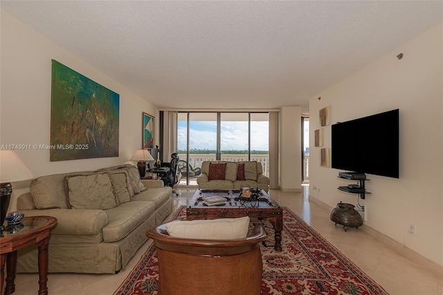 living area with a wall of windows, light tile patterned flooring, a textured ceiling, and baseboards