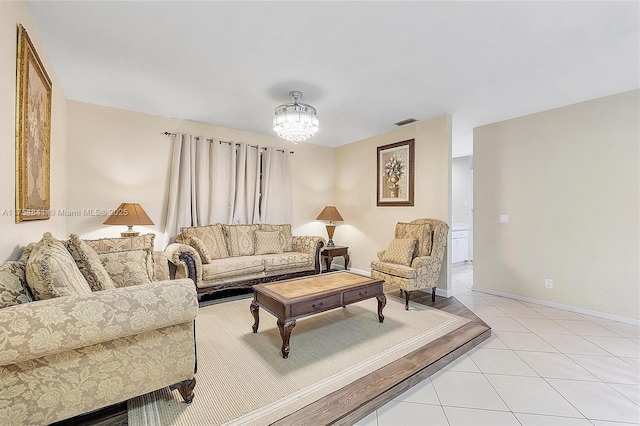 living area with visible vents, a notable chandelier, baseboards, and light tile patterned floors