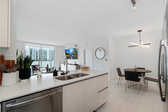 kitchen with light countertops, a sink, stainless steel dishwasher, and modern cabinets