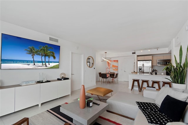 living room featuring rail lighting, visible vents, and light tile patterned flooring