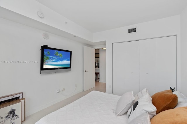 bedroom with baseboards, visible vents, and a closet