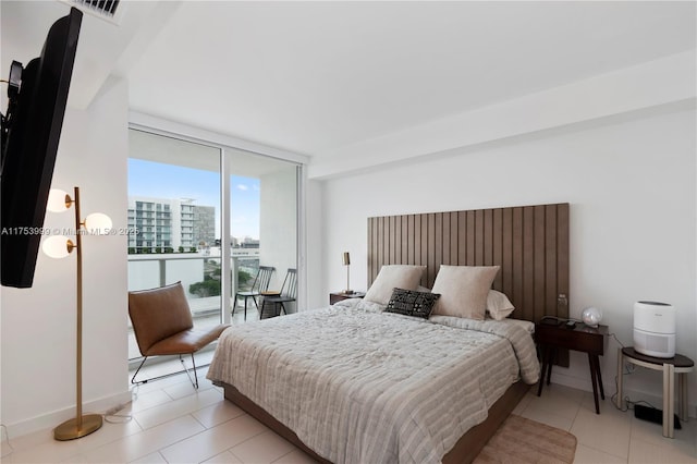 bedroom with baseboards, visible vents, access to outside, expansive windows, and a city view