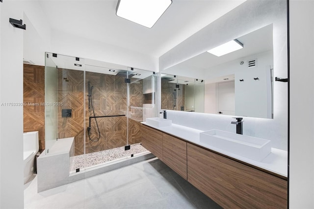 bathroom featuring double vanity, a sink, visible vents, and a shower stall