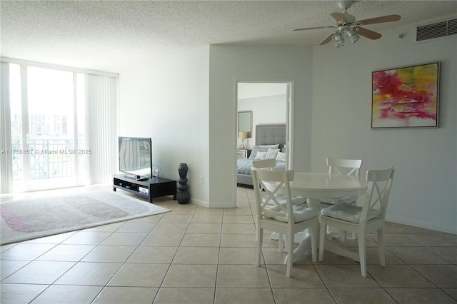 dining space with light tile patterned floors, a textured ceiling, and visible vents