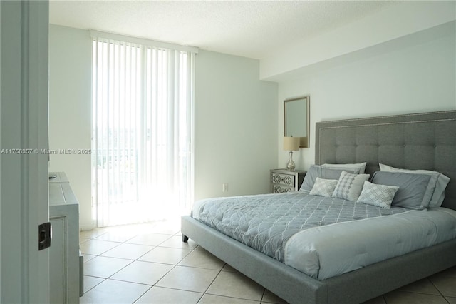 bedroom with a textured ceiling and light tile patterned flooring