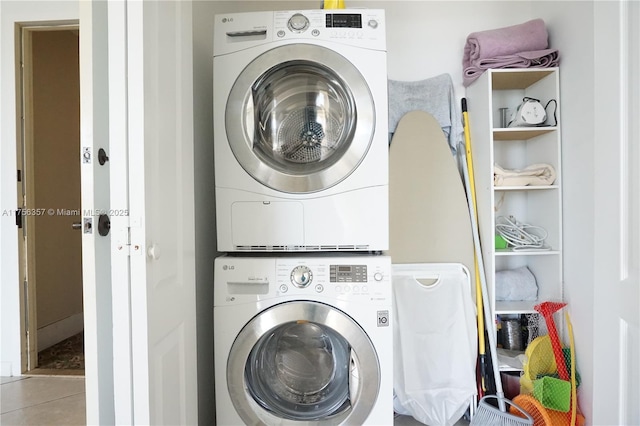 laundry room with stacked washer and dryer, tile patterned flooring, and laundry area