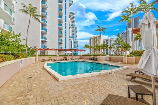 community pool with a patio area and a city view