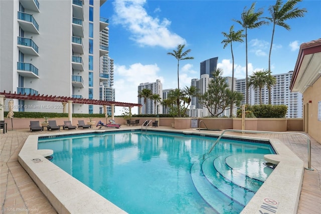 community pool featuring a view of city and a patio area