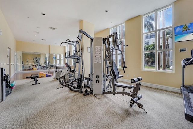 exercise room featuring carpet floors, baseboards, and visible vents