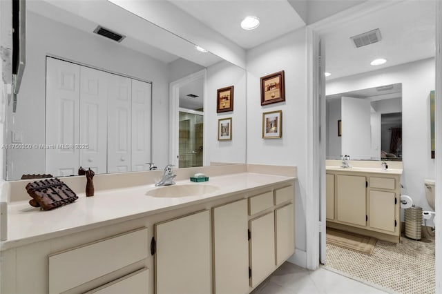 full bathroom with a stall shower, two vanities, visible vents, and a sink