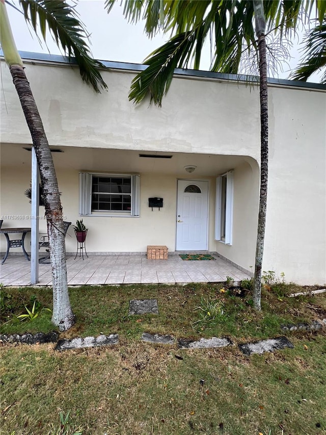 entrance to property with stucco siding