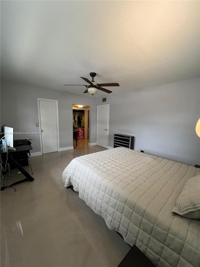 bedroom featuring ceiling fan, a closet, tile patterned floors, and baseboards