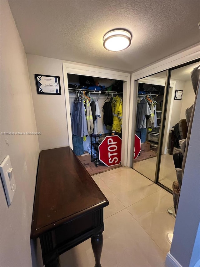 mudroom with a textured ceiling and tile patterned floors