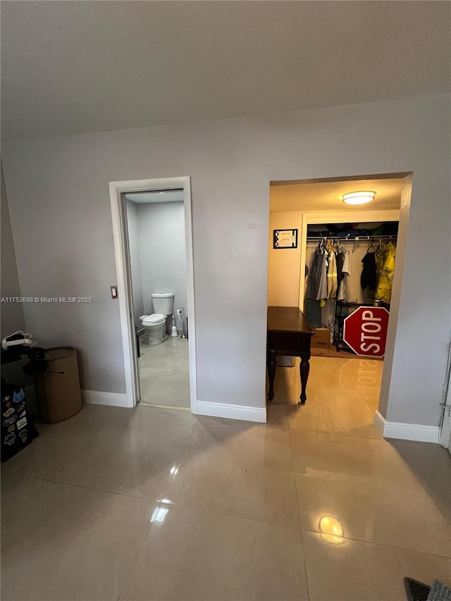 hall with tile patterned floors, visible vents, and baseboards