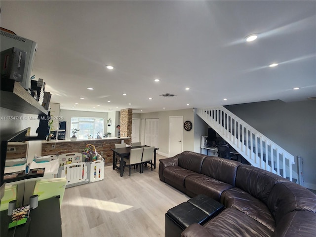 living room featuring recessed lighting, visible vents, light wood-style flooring, and stairs