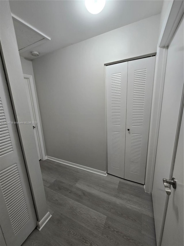 unfurnished bedroom featuring a closet, baseboards, and wood finished floors