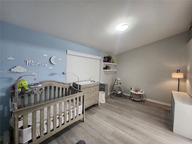 bedroom with baseboards and wood finished floors