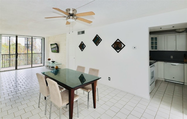 dining space with light tile patterned floors, a textured ceiling, visible vents, a ceiling fan, and expansive windows