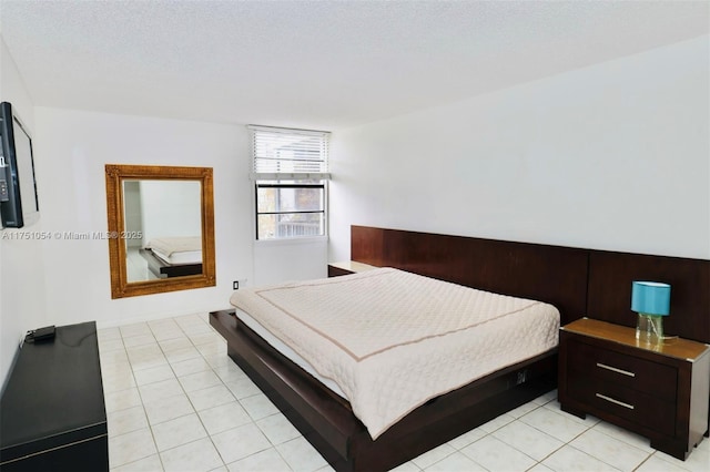 bedroom with light tile patterned floors and a textured ceiling