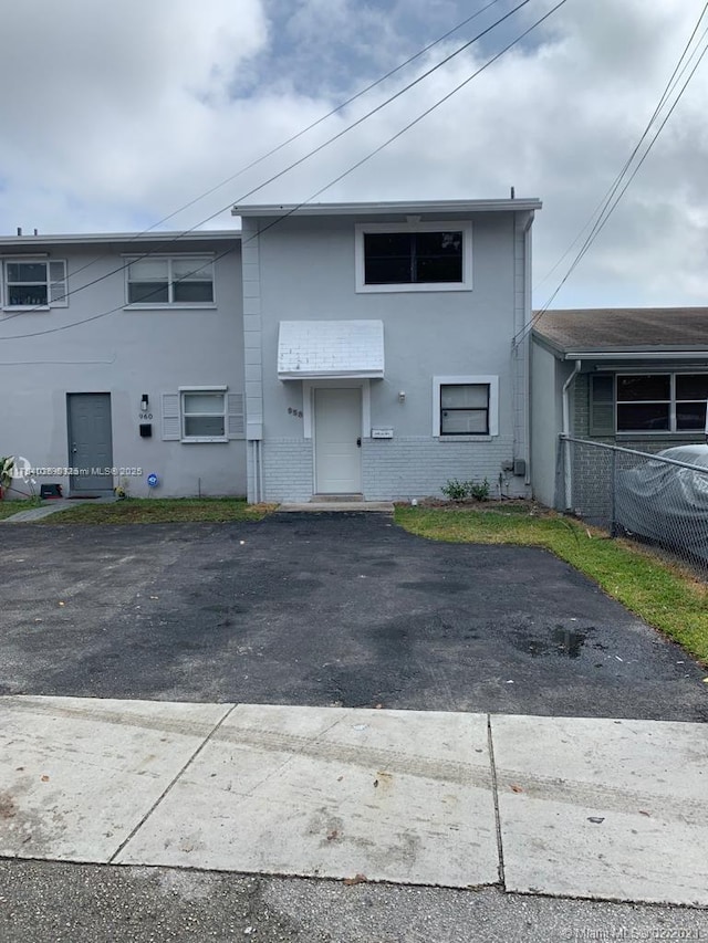 multi unit property featuring brick siding, fence, and stucco siding