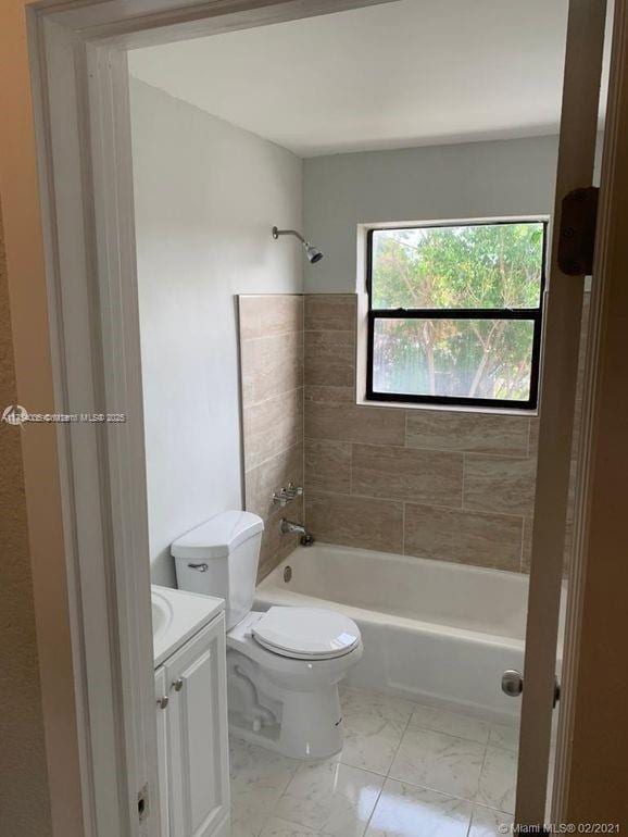 full bath with toilet, marble finish floor, washtub / shower combination, and vanity