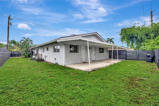 rear view of property featuring a yard, a patio area, a fenced backyard, and stucco siding