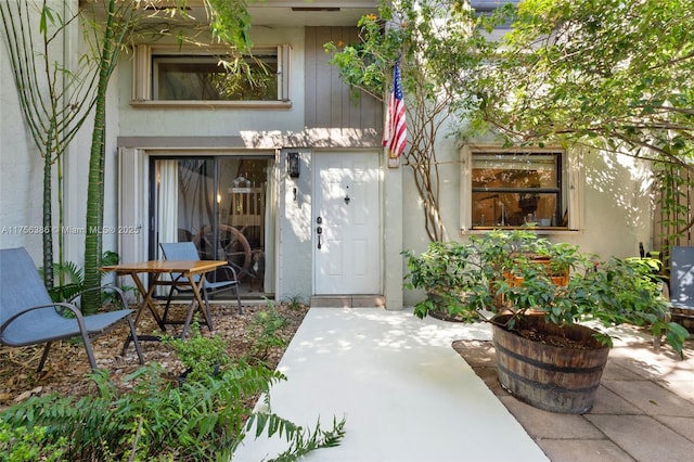 property entrance with a patio and stucco siding