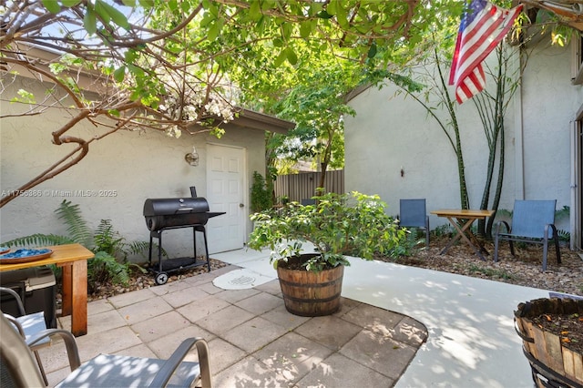 view of patio featuring a grill and fence