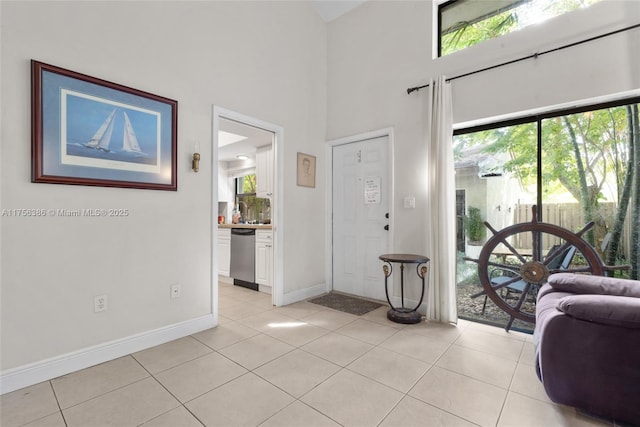 entryway featuring light tile patterned floors, a wealth of natural light, and baseboards