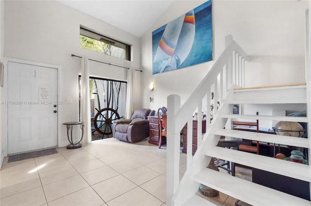 tiled foyer entrance featuring a high ceiling and stairway